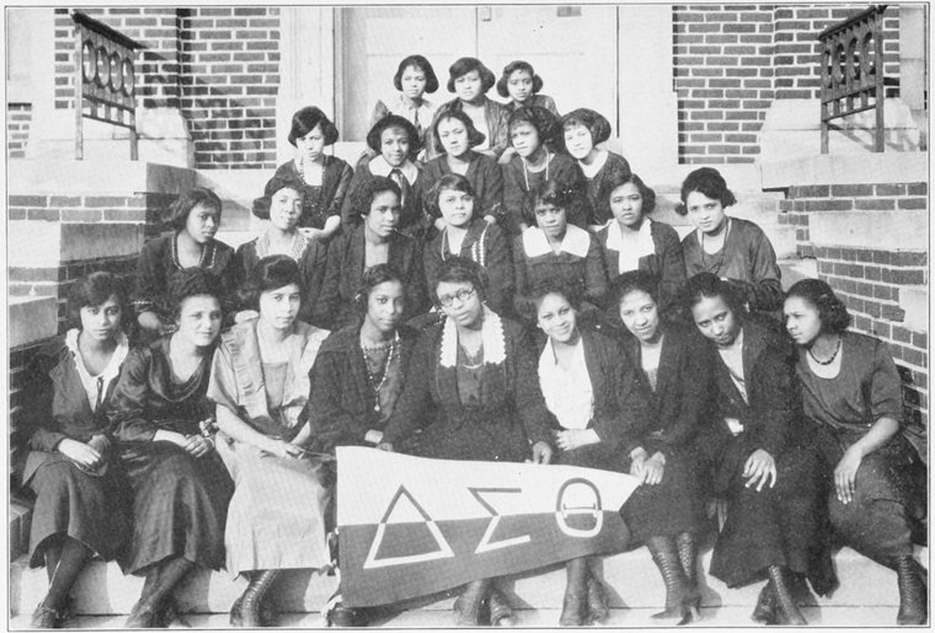 A group of women gathered on steps with a Delta Sigma Theta banner.