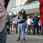 Woman with a bullhorn speaks to a crowd.