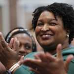 Stacey Abrams clapping in a crowd of people.