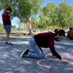 Olivia Eaton, a student majoring in classical medieval studies and minoring in gender studies at Bates College, on Saturday crafts a sidewalk chalk mural on the campus in Lewiston, Maine, honoring U.S. Supreme Court Justice Ruth Bader Ginsburg after her death the day prior.