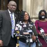 Tamika Palmer, mother of Breonna Taylor, stands in front of microphones addressing press.