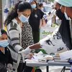 Volunteer Sequaña Williams-Hechavarria, right, instructs youngster Jade Suarez to look beneath the table for books as Jade's mother, Maria, signs up for assistance and free supplies provided by Sistas Van during the coronavirus outbreak at a busy Bushwick intersection in the Brooklyn borough of New York, Tuesday, May 19, 2020. Sistas Van was originally launched by the nonprofit Black Women's Blueprint to help survivors of sexual and reproductive violence and physical abuse. But during the coronavirus, the women's network has pivoted to delivering badly-needed resources to black and Hispanic communities, which have had some of the city's highest rates of contagion and death toll of the fast-spreading virus.