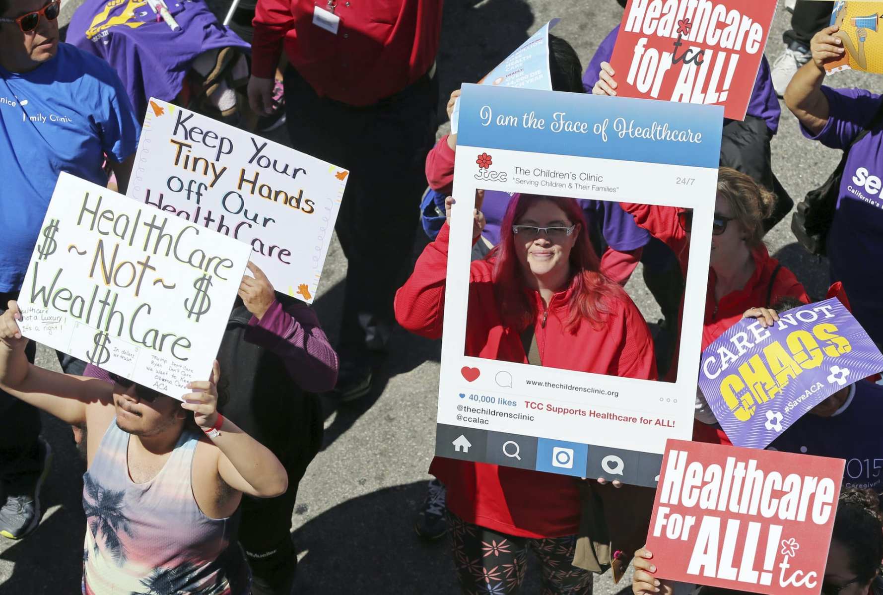 A woman holds an Instagram-inspired frame around her head reading "I am the face of healthcare."