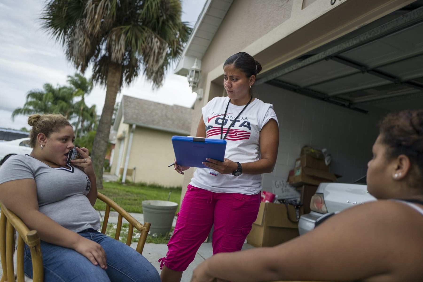 Soraya Marquez, the state coordinator for Mi Familia Vota and her crew hit a Puerto Rican neighborhood trying to get Latinos to register to vote in the 2016 presidential election on July 24, 2015 in Kissimmee, FL. Jeamy Ramirez gets a young girl (18) to register to vote in a Puerto Rican neighborhood in Kissimmee. (Photos by Charles Ommanney/The Washington Post via Getty Images)