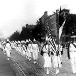 A line of women marching in a KKK parade.