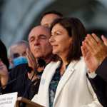 Paris Mayor Anne Hidalgo stands at a podium.