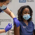 An ER doctor closes her eyes as she receives the COVID-19 vaccine.