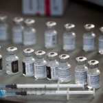 Close-up of syringes and vials of the Pfizer-BioNTech Covid-19 vaccine sitting on a table.