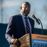 Raphael Warnock speaking at a podium.