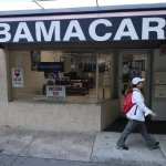 A woman walks past a lending agency with a large Obamacare sign.