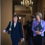 Sen. Susan Collins (R-ME) and Sen. Lisa Murkowski (R-AK) walk together down a hallway.