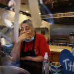 Owner Julie King, in a red shirt covered by an apron, holds back tears at Villa Mexico Cafe on Water Street in Boston, MA. A customer had just walked out while she was on the phone with another customer who was trying to negotiate the price of an order. Having lost two customers in a matter of minutes she said, 