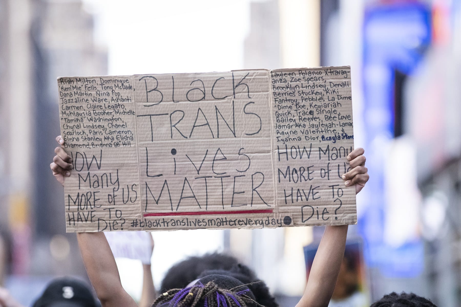 A protester holds a sign that says, "Black Trans Lives Matter".