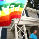 LGBTQ+ flag flying in front of a home.