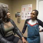A doctor speaks with a patient during a routine doctor visit.
