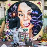 Tamika Palmer, mother of Breonna Taylor, poses for a portrait in front of a mural of her daughter.