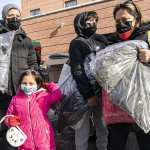 New York Cares volunteers work with a local non-profit organization to distribute toys and winter coats in Corona, Queens.