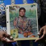 Antoinette Dorsey-James holds a picture of her sister Pamela Turner during a news conference.