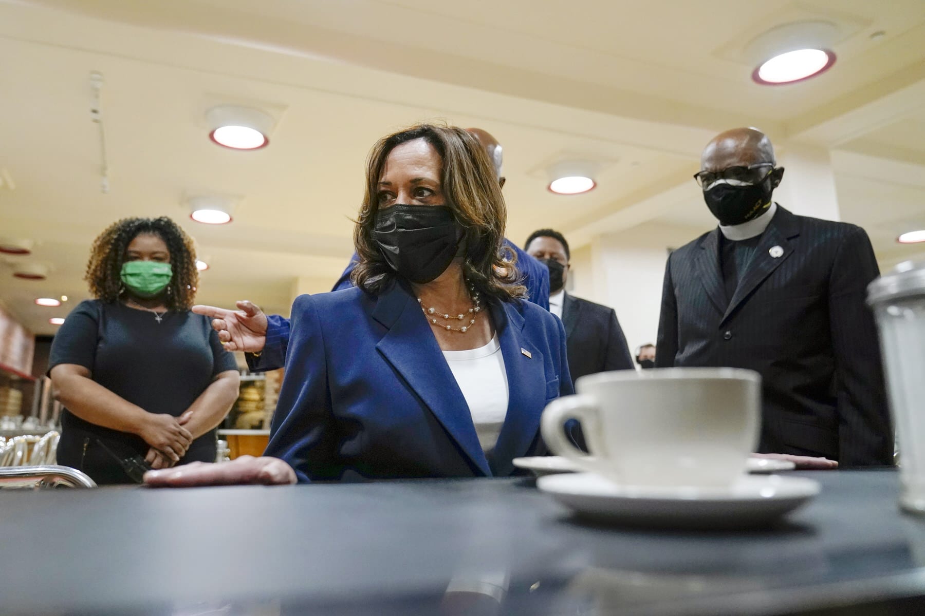 Vice President Kamala Harris sits at the lunch counter as others look on while she visits the International Civil Rights Center and Museum.