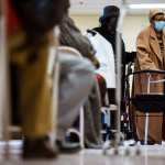 A woman who has just received her Moderna COVID-19 vaccine is escorted by her daughter into the post-injection observation area.