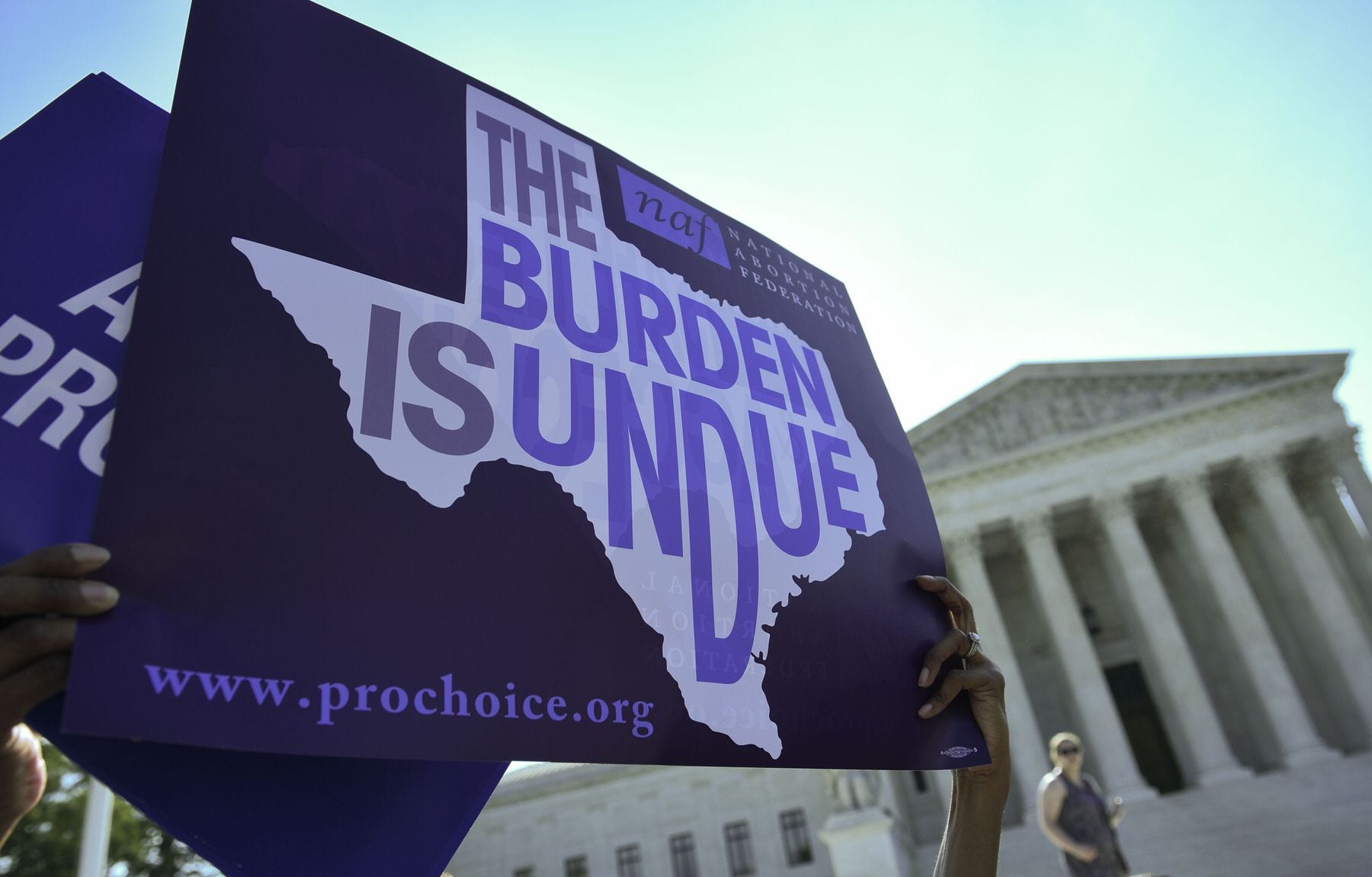 A sign that reads "The burden is undue" inside of the outline of Texas.