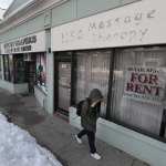 A person walks by an empty massage parlor.