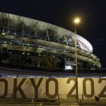 The outside of the Olympic Stadium in Tokyo at night.