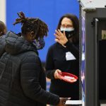 A woman holding a young child casts her vote in the Georgia run-off election at Dunbar Neighborhood Center.