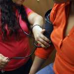 A medical assistant checks a patient's blood pressure.