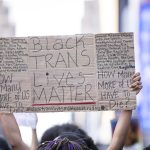 A protester holds a sign that reads, 