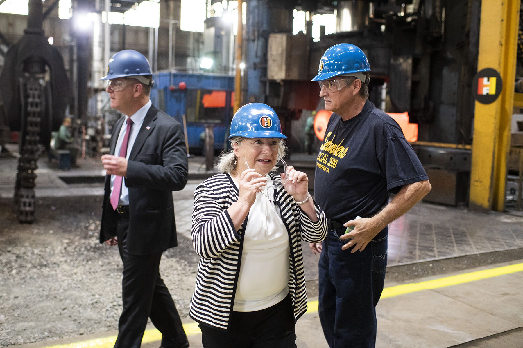 Rep. Susan Wild wears a hard hat and protective glasses while visiting a forge.