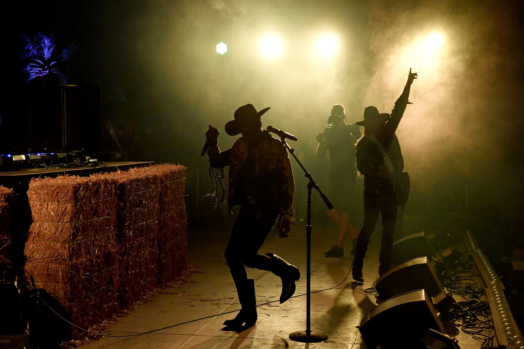 The silhouetted figures of Lil Nas X and Billy Ray Cyrus are seen singing and dancing on stage.