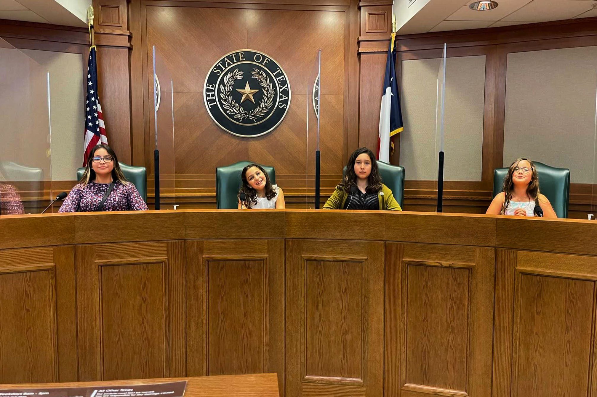 Four young girls sit inside the Texas State Capitol.