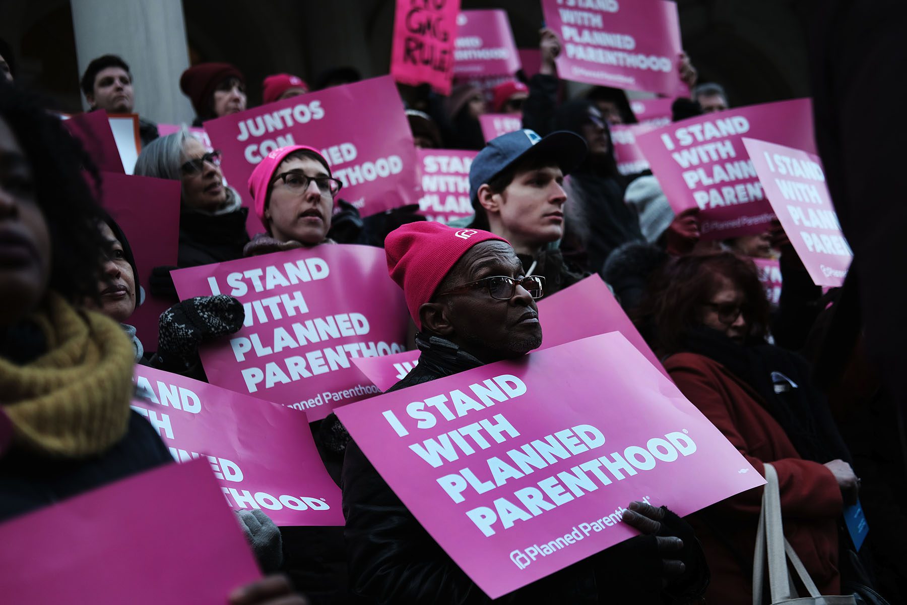 A diverse crowd of people hold signs that read "I Stand With Planned Parenthood"