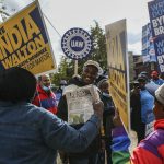 People hold signs for India Walton and Byron Brown in Buffalo