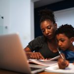 A mom helps her son with homework at home.