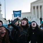 Demonstrators hold boxes of abortion pills in front of the U.S. Supreme Court.