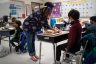 A teacher helps a student during class at an elementary school.