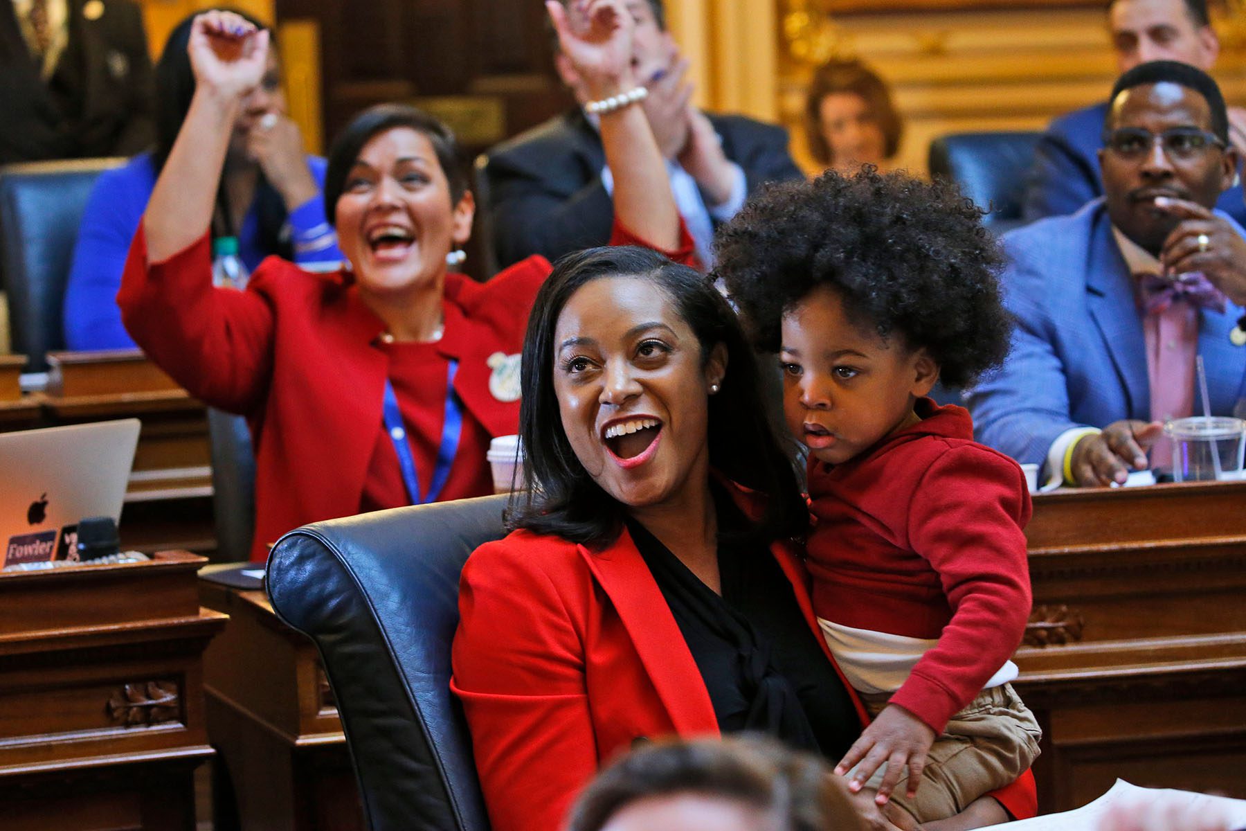 Jennifer Carroll Foy holds her son as she celebrate the passage of the ERA in Virginia