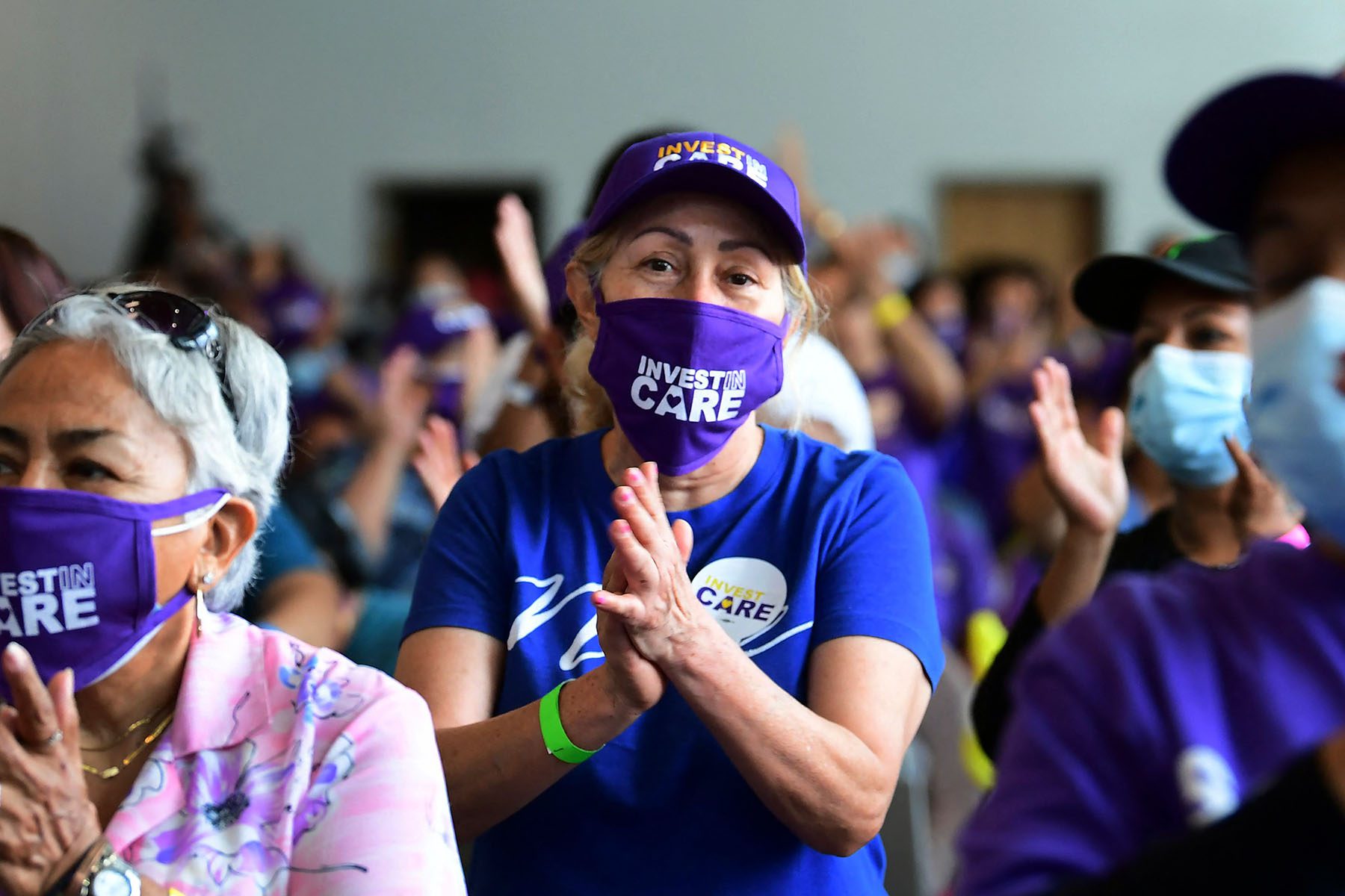 Caregivers smile and applaud during a rally.