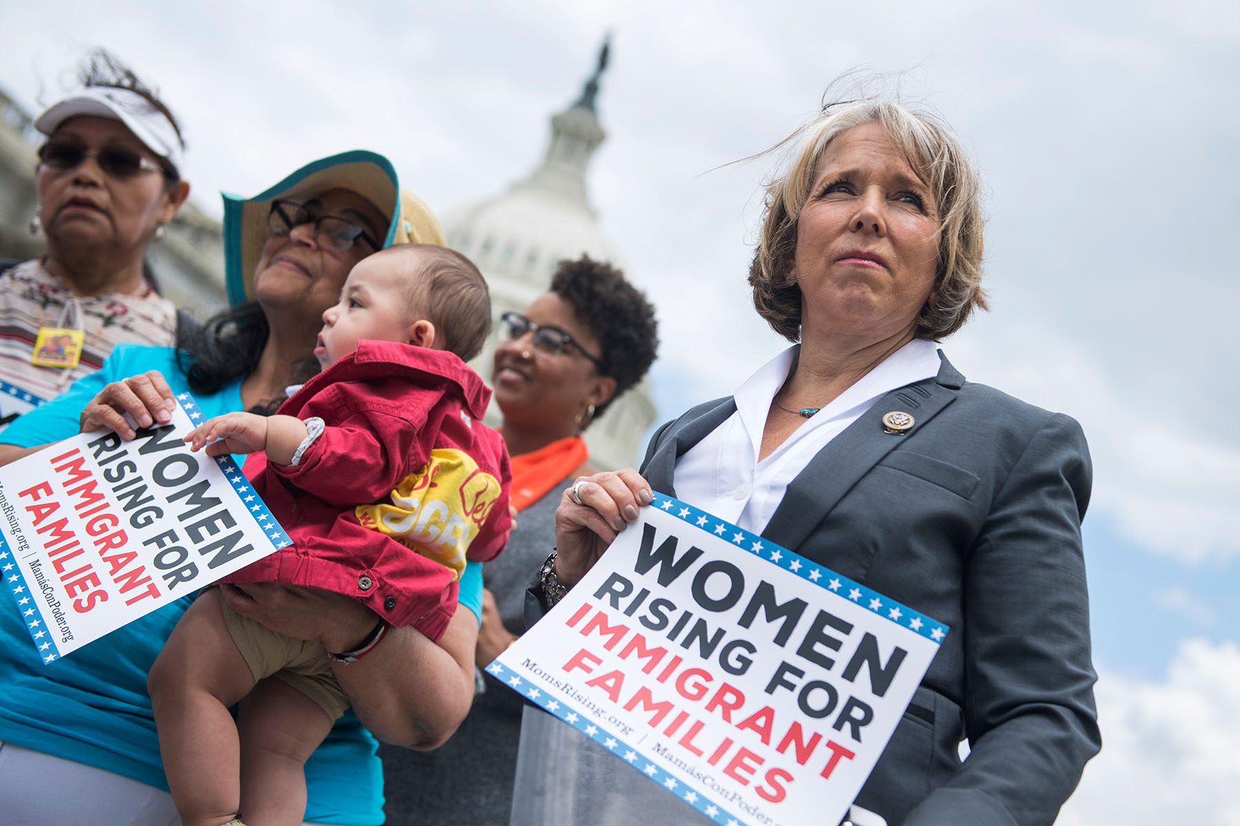 Michelle Lujan Grisham holds a sign that reads "Women rising for immigrant families" in front of the U.S. Capitol.