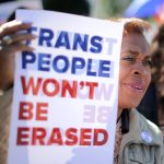 An activist holds a sign that reads 