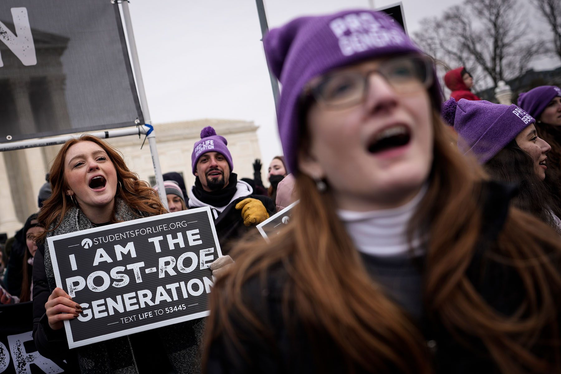 Anti-abortion activists rally outside the Supreme Court. One person holds a sign that reads "I AM THE POST-ROE GENERATION."