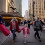 A family wears face masks as they walk through New York City.