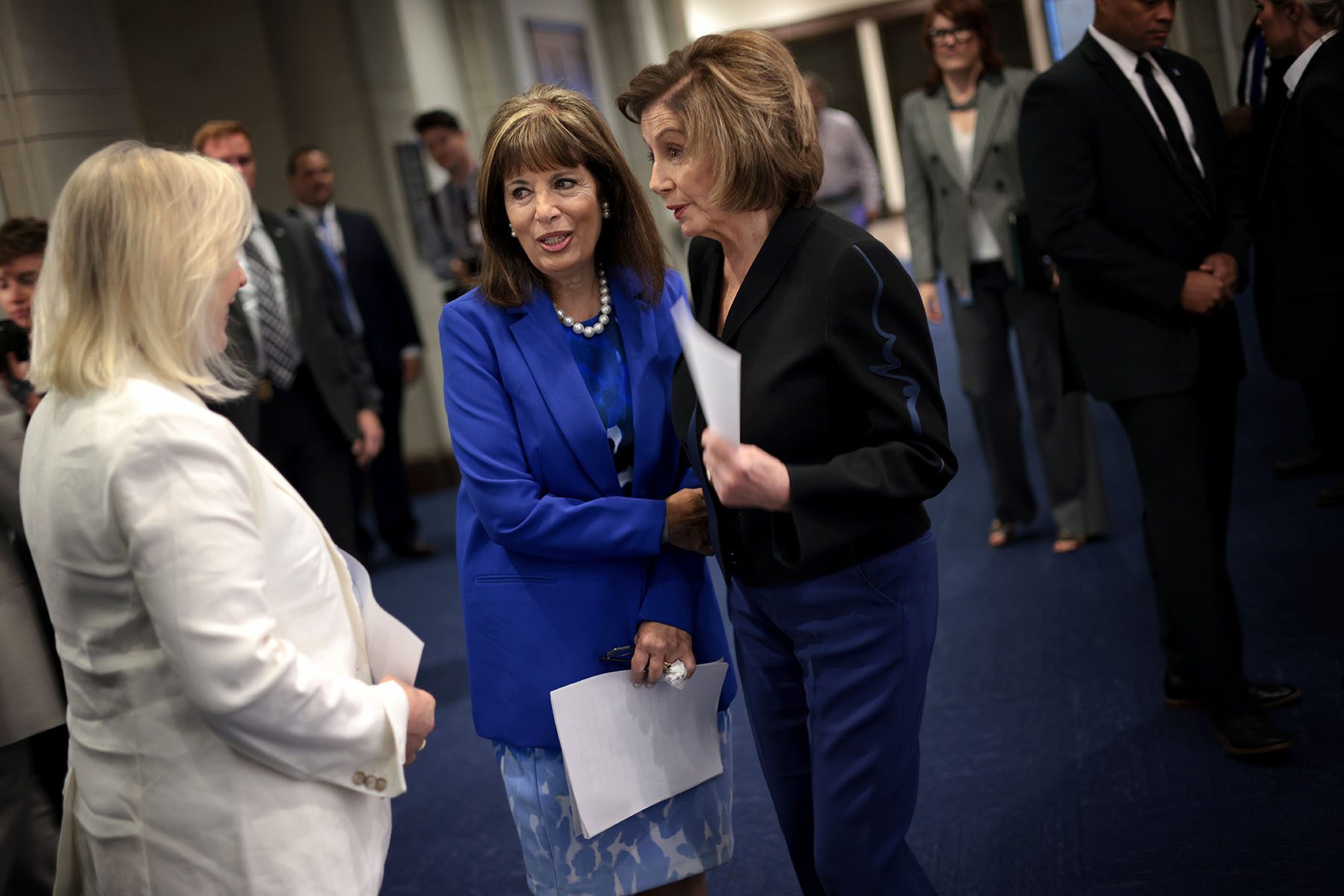 Nancy Pelosi confers with Rep. Jackie Speier and Sen. Kirsten Gillibrand in a hallway before a press conference.