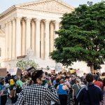 Crowds are seen protesting in front of the Supreme Court.