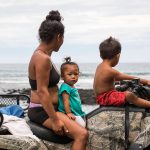 Shanelle Casuga and her children watch the coast on an ATV before the arrival of a hurricane.