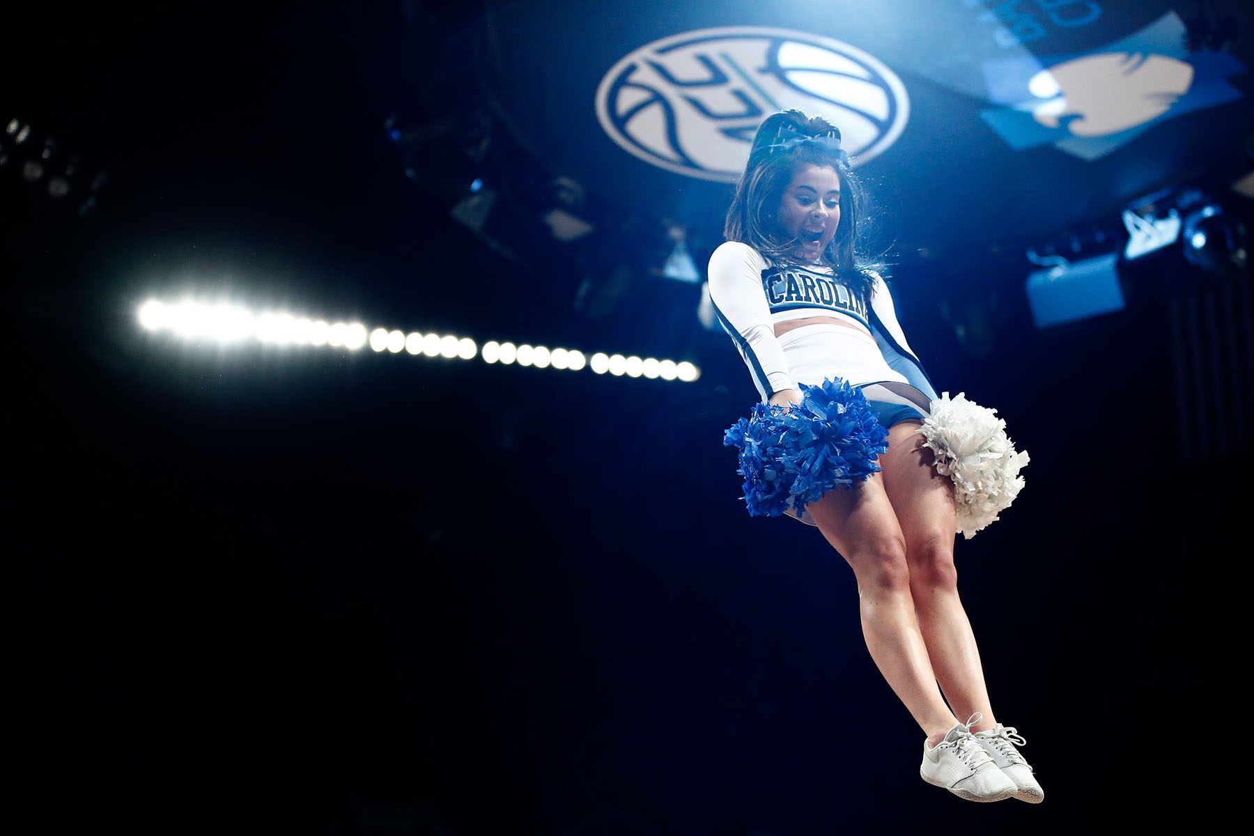 A North Carolina Tar Heels cheerleader is thrown into the air while performing.