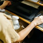 Person pumping breast milk while working on a computer.