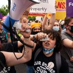 Abortion rights activists chant and hold signs during a rally.